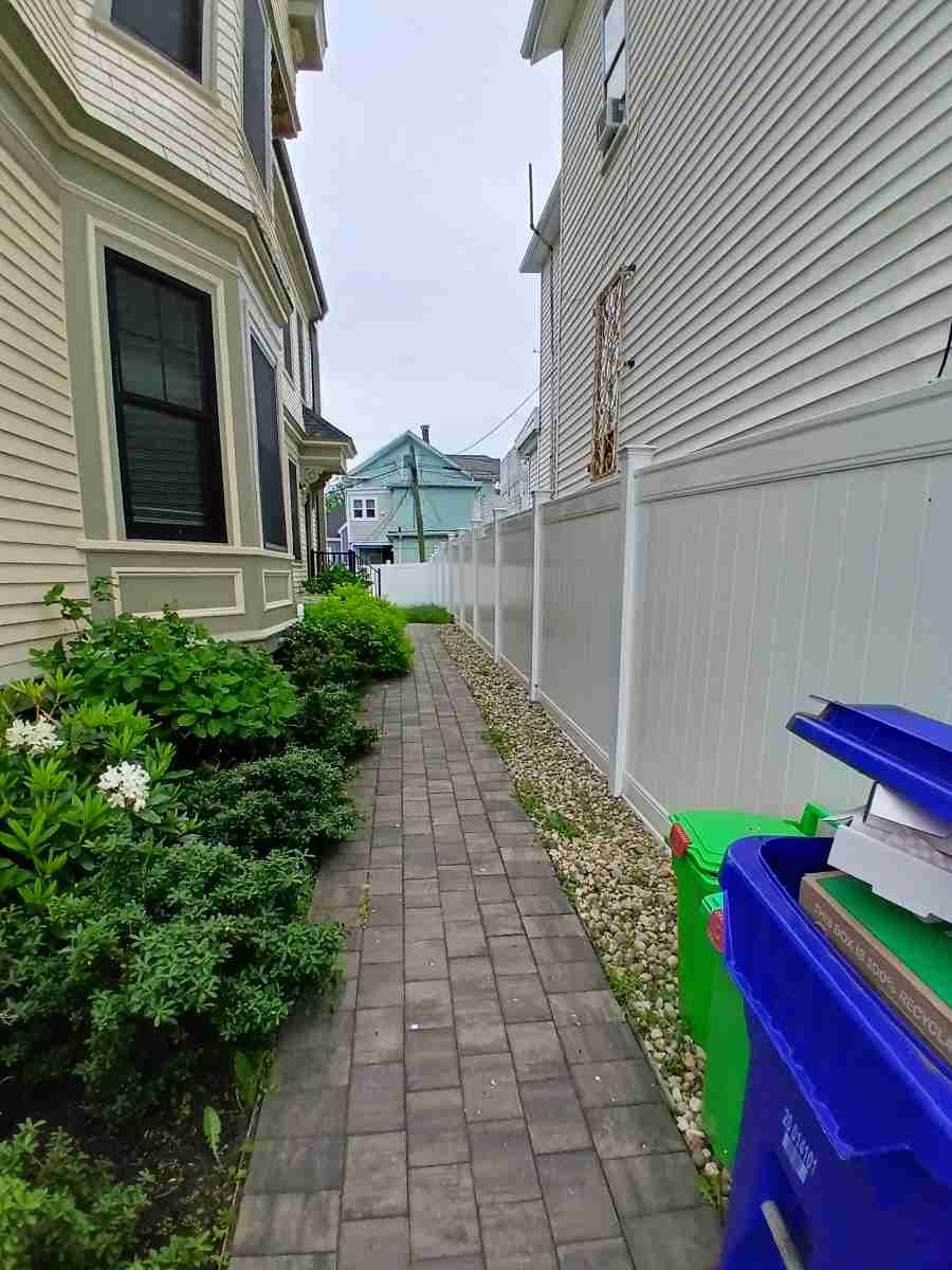A clean, edged brick walkway between two Boston homes.
