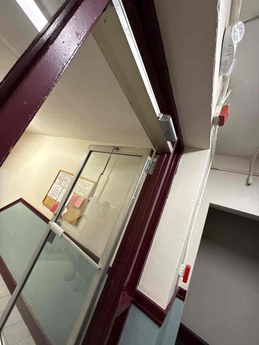A new closer mounted on a common-entry door so it shuts and latches on its own every time.