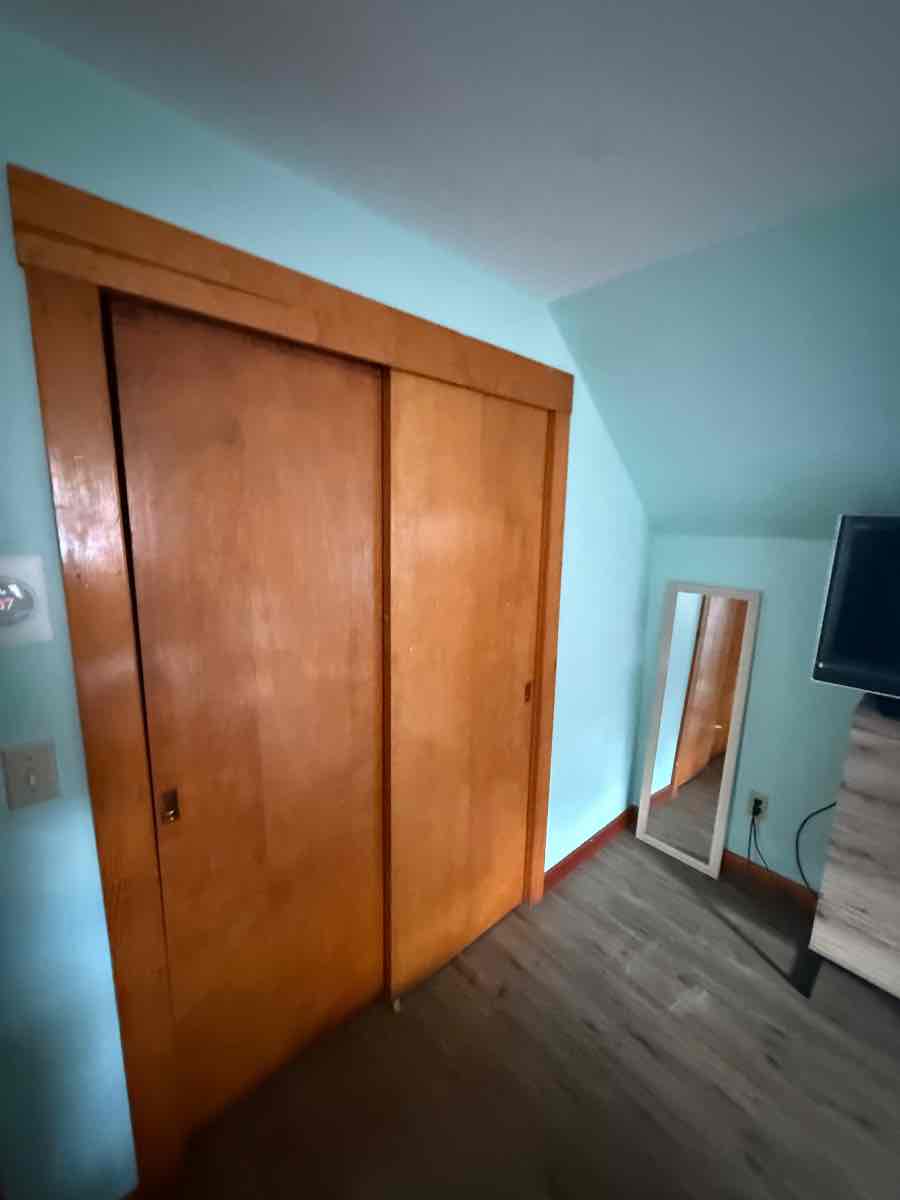 Original sliding bypass closet doors in an older Boston home — the kind that bind on their track and get forced.